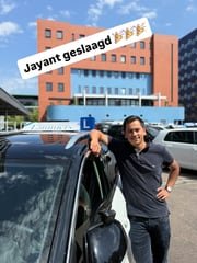 Geslaagde leerling bij de lesauto van Rijschool Lammers