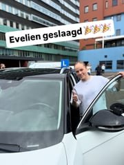 Geslaagde leerling bij de lesauto van Rijschool Lammers