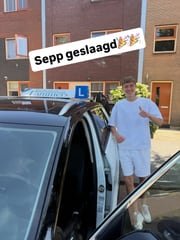 Geslaagde leerling bij de lesauto van Rijschool Lammers